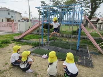 2つののぼり棒に両足をかけて登っている様子