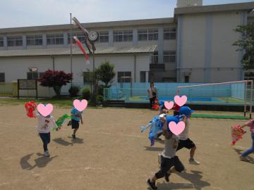 こいのぼりを持って園庭を走っている様子