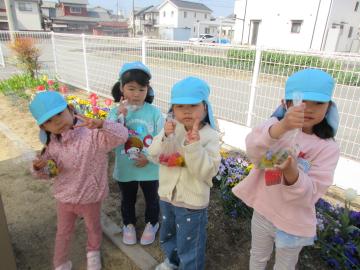 園庭でお花を使って色水を作る園児の様子