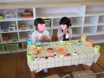4歳児が遊戯室でままごとをしている写真