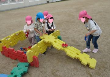 園児が園庭で大型ブロックで遊んでいる写真