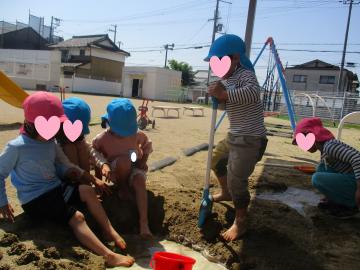 園児が砂場で遊んでいる様子