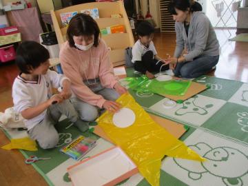 ポリ袋に目玉をつけてこいのぼりをつくる親子
