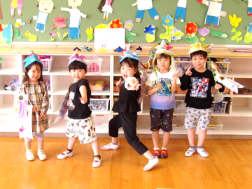 幼児が兜をかぶってポーズをとる様子