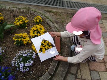 4歳児が花壇で製作活動をする様子