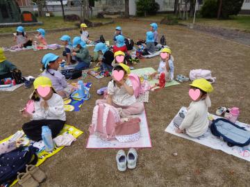 屋外で4歳児がお弁当を食べている様子