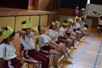 体育館で王冠をかぶり並ぶ1年生
