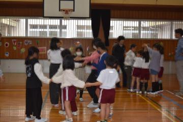 体育館で人間知恵の輪をして遊ぶ児童