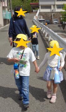 園出発（手を繋いで地域の散歩に出かける園児と先生）