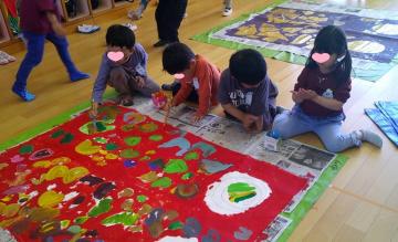 室内で5歳児がグループでこいのぼりを作っている写真