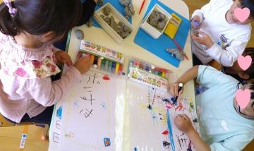 室内で5歳児が家族に向けて手紙を書いている様子