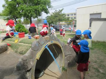 園庭で子供たちが基地作りをしているところ