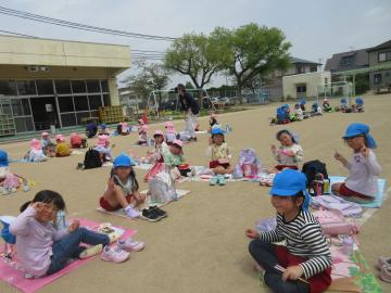 園庭で園児がお弁当を食べているところ