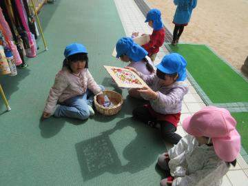 廊下で園児がお花の影遊びを楽しんでいるところ