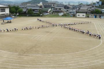 運動場で児童が2つ目の隊形を整えている様子