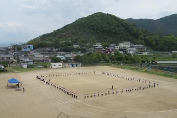 運動場で児童がはじめの隊形を整えている様子