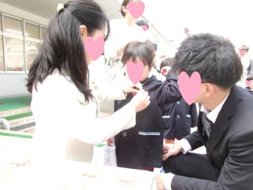 入園式で名札をつけてもらっている様子