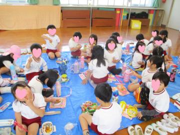 4歳児5歳児が遊戯室で昼食を食べている様子