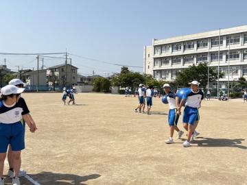 3年生が運動場で学年競技のボール運びの練習をしているようす