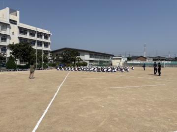 3年生が運動場で集合隊形で並んでいるようす