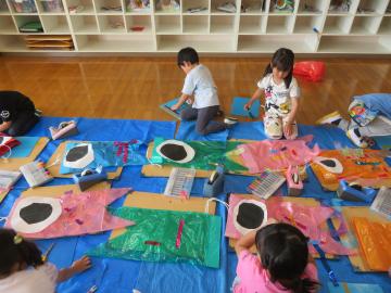 5歳児が遊戯室で自分のお気に入りのこいのぼりをつくっています。