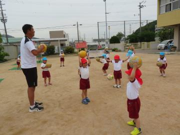 幼稚園児が園庭でサッカー遊びをしている様子