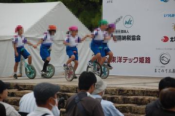 5人で手をつないで一輪車に乗る演技の様子