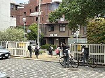 自転車で校門を出る様子