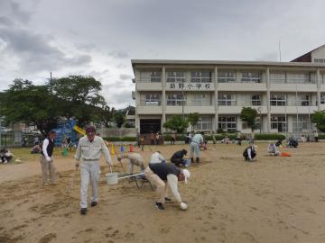 運動場の掃除を親子でする様子1