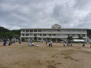 運動場で掃除を親子でする様子2