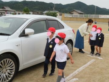 路上駐車している車のところで安全確認する1年生