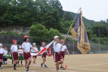 校旗を先頭に入場する5・6年生の様子