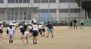校庭で子供たちが動きを止めている様子