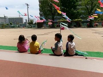 鯉のぼりを眺めながら座っている写真