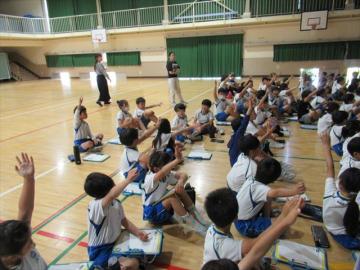会場で児童が手をあげて発表する様子