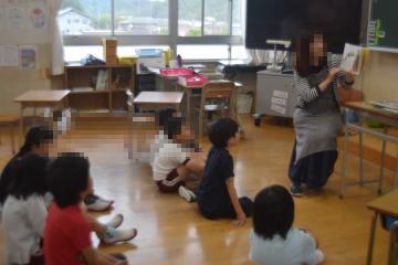 4年生が「びゅんびゅんごまがまわったら」の読み聞かせを聞く様子