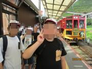 駅のホームでトロッコ電車をバックに撮った児童の写真