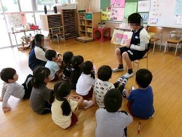 中学生が絵本の読み聞かせをしている写真