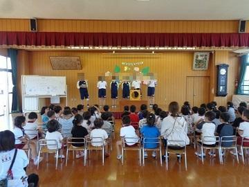 中学生が園児の前でお別れ会をしている写真