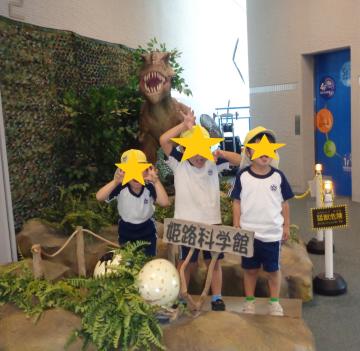 恐竜と記念撮影をする子ども