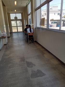 廊下で担任と相談する様子