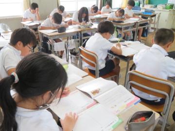 教室内で学習のふり返りをノートにまとめる5年生の様子
