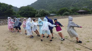 砂浜で地引網をする児童たちの様子