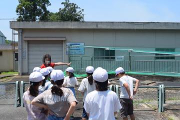 着水井(浄水の施設)を見学し説明を聞く児童の様子