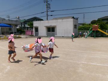5歳児が園庭でこいのぼりと走っているところ