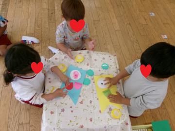 3歳児がこいのぼりのうろこをのりでつけているところ