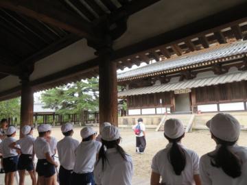 法隆寺の木造建築についての説明を聞く6年生