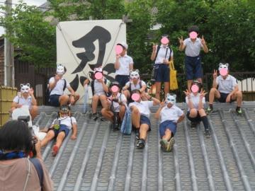 屋根の上で記念写真を撮る6年生
