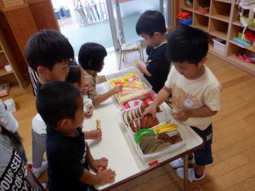 ハンバーガー屋さんごっこをする幼児