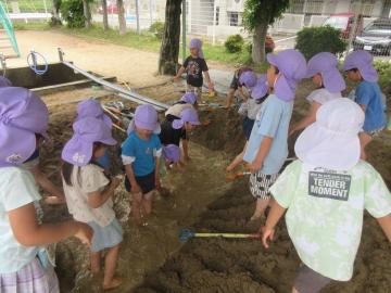 砂場で川づくりをする幼児